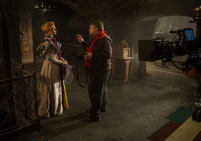 Guillermo del Toro tengah berbicara dengan Mia Wasikowska di depan kamera